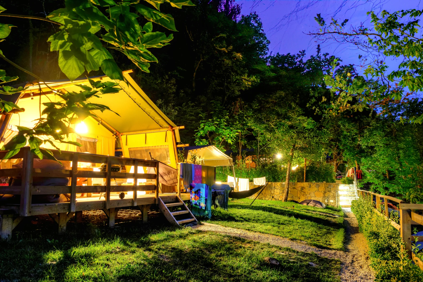 Verlichte lodges in de avond op Camping Delle Rose