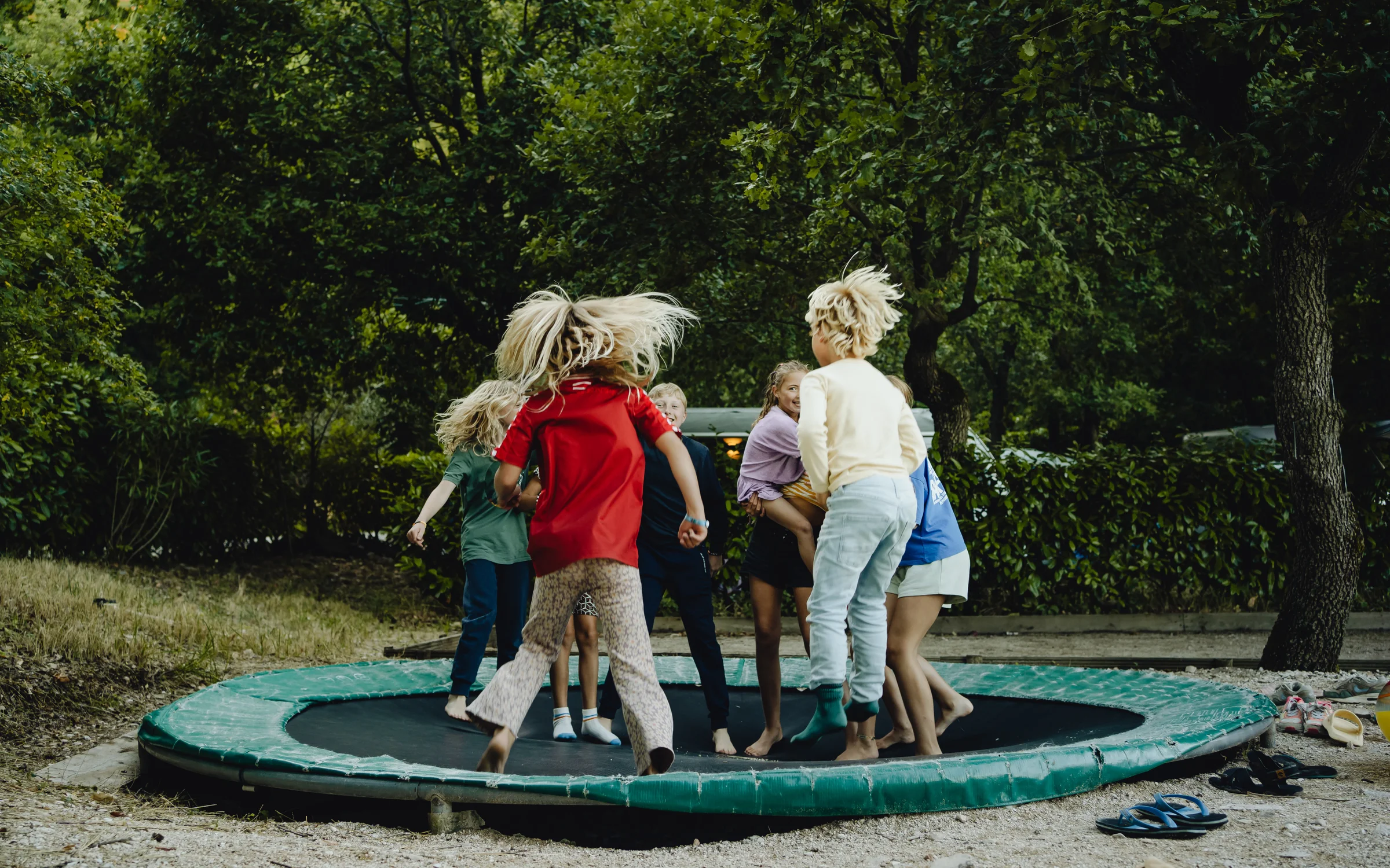 Kinderen springen op de ingegraven trampoline op een van onze campings