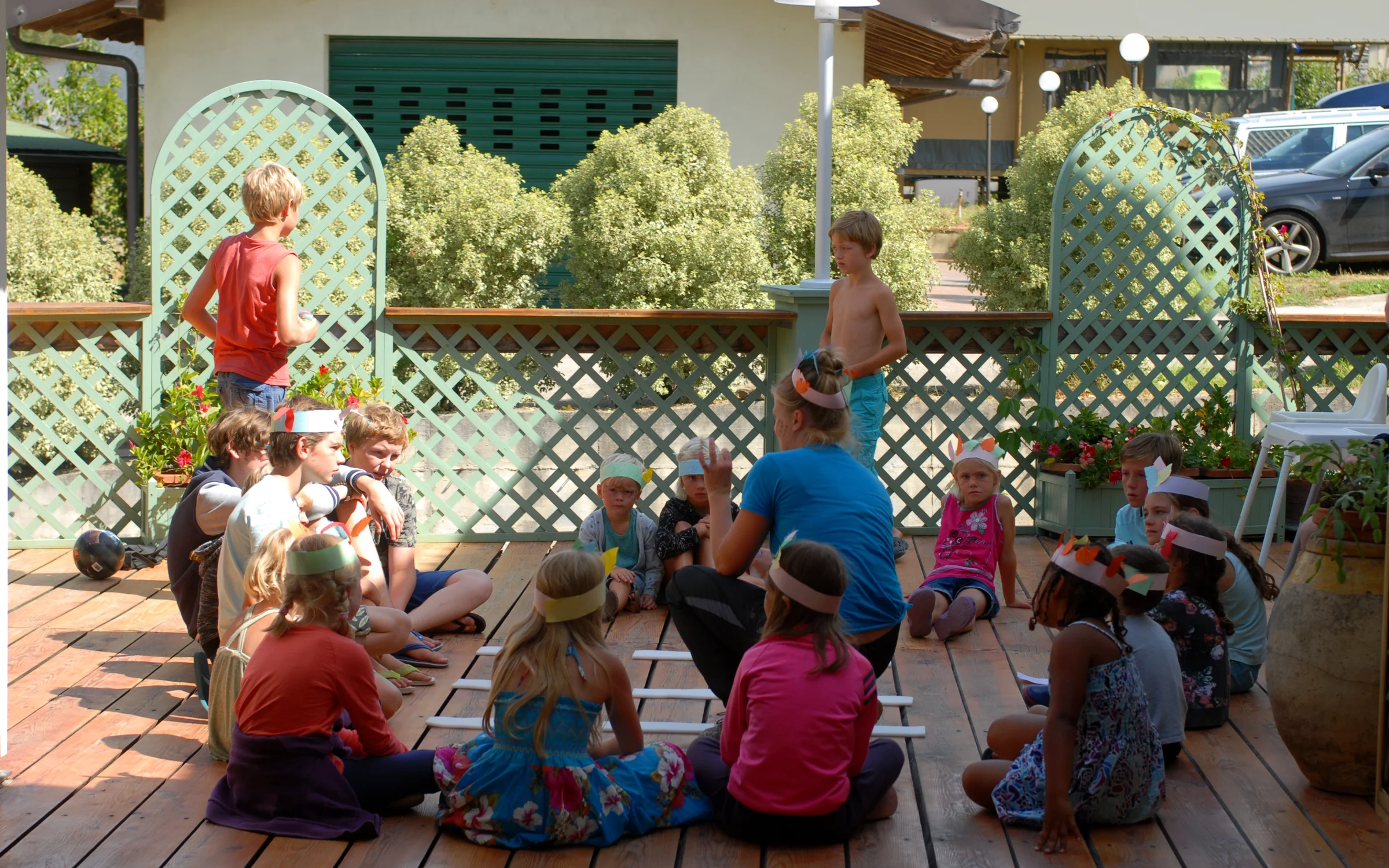 Kinderen zitten in een kring op het terras tijdens een activiteit op de camping