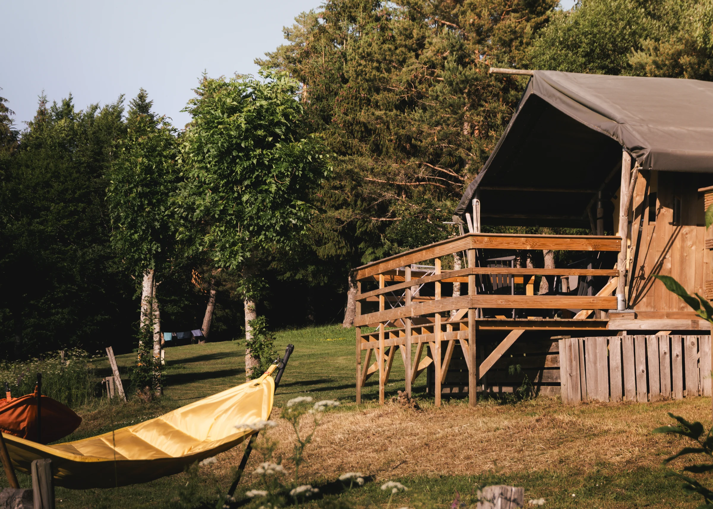 Base Lodge s drvenom terasom i visećom mrežom među stablima